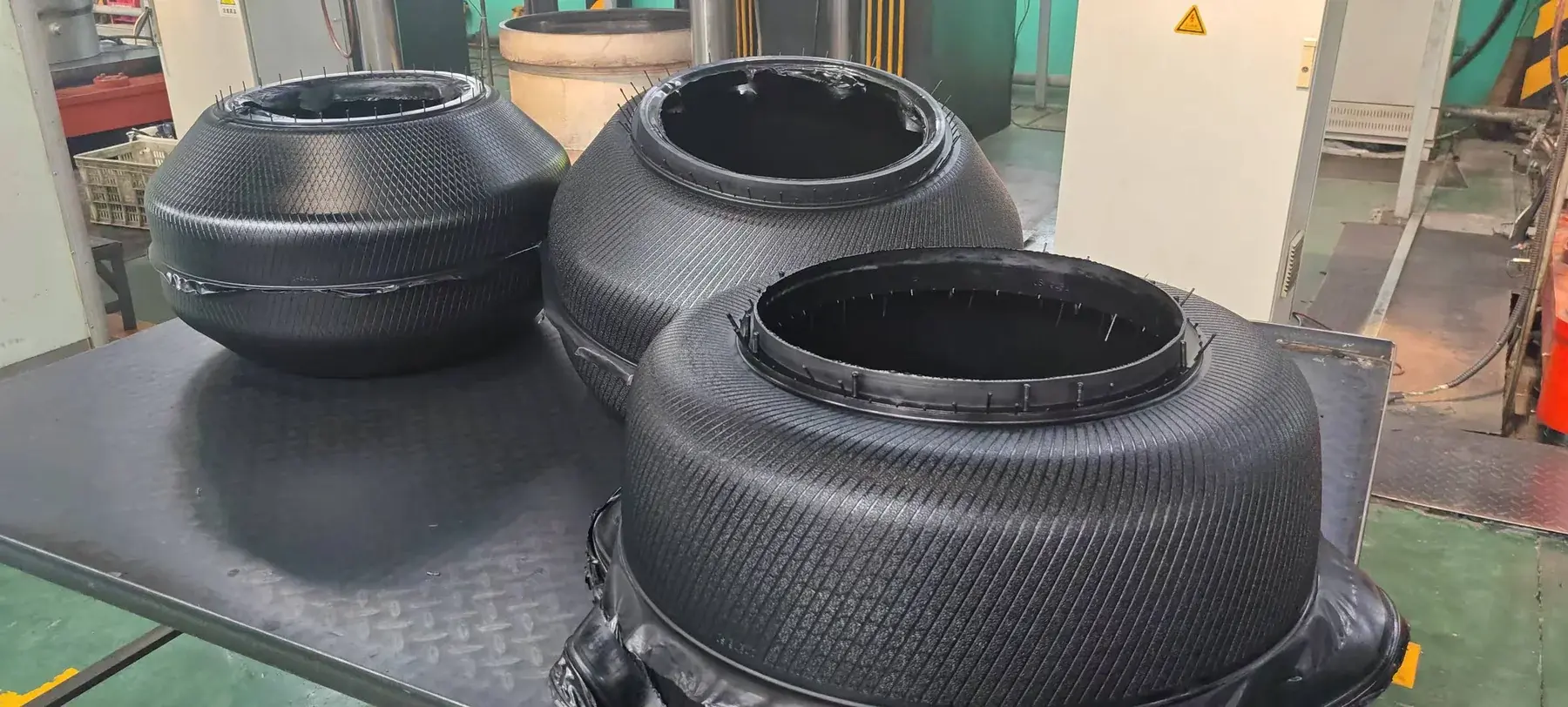 Tire curing bladders on a worktable in a manufacturing supply facility